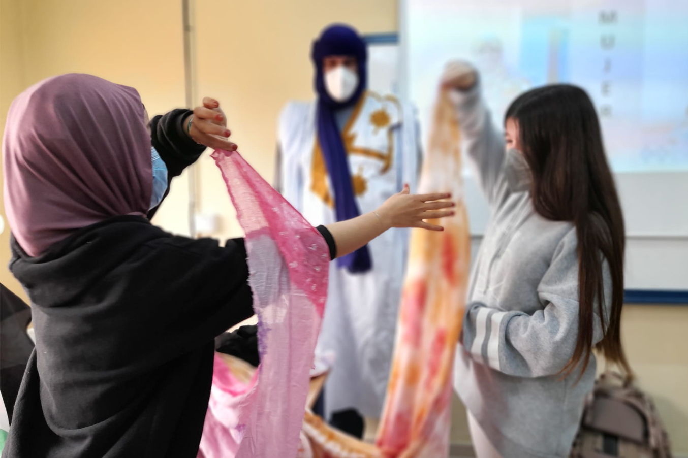 Mujeres musulmanas junto a una alumna en un taller de velos